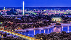 Aerial view of Washington DC at dusk, with the Capitol, Washington and Jefferson monuments lit up